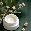 Krim malam yang kaya dan masker tidur, di samping bunga melati yang harum.