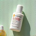 Botol serum ringan dan krim pelindung matahari di cahaya pagi hari.